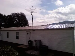 New metal roof on a single wide mobile home with a TV antenna in Shenandoah